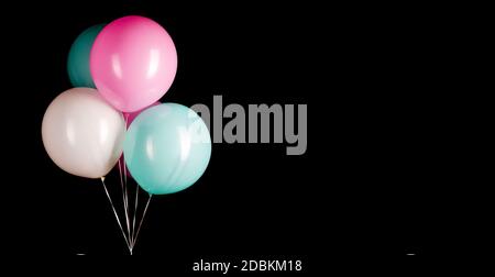 Eine Gruppe von bunten Party-Ballons auf schwarzem Hintergrund Mit Kopierbereich Stockfoto