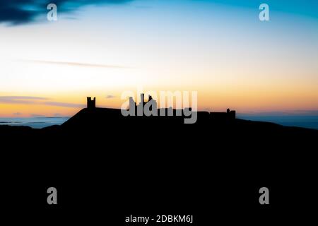 Eine Spätsommernacht in Northumberland mit Blick nach Norden über Dunstanburgh Castle. Stockfoto