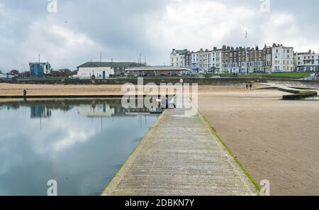 Mann malt auf dem Gezeitenpool am Strand von Marine Terrace, Margate, Kent Stockfoto