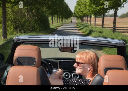 Älteres Ehepaar in Love Ride in Cabrio Stockfoto