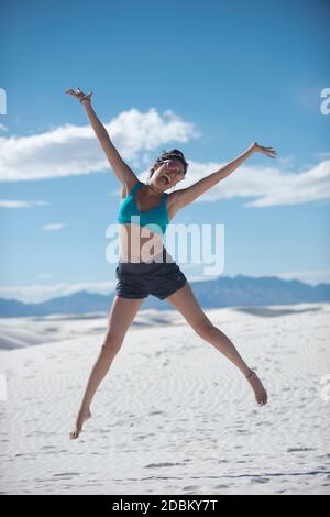 Frau springt vor Freude in der Wüste, White Sands National Monument, New Mexico, USA Stockfoto