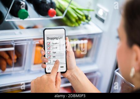 Praktische Lebensmitteleinkaufsliste Telefon App In Der Nähe Kühlschrank Stockfoto
