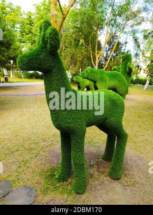 Skulptur eines Hirsches im Profil in einem grünen Park vor einem Hintergrund von Bäumen. Stockfoto