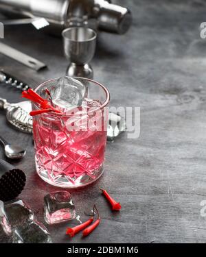 Kosmopolitischer Cocktail in einem Glas, das mit rosa Blumen aus nächster Nähe dekoriert ist Stockfoto