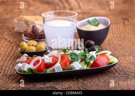Oliven und Hummus auf dunklem Holz Stockfoto