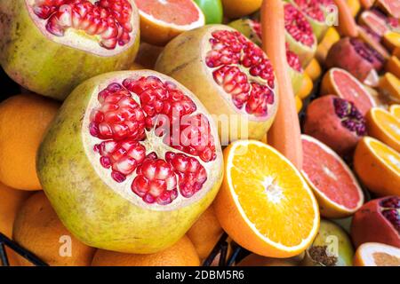 Frisch geöffneter Granatapfel in der Ausstellung auf dem lokalen Markt in Istanbul, Türkei für gesunden Saft zu machen. Nahaufnahme von Punica granatum zwischen den Früchten Stockfoto