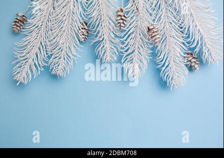 Frohe Weihnachten und ein glückliches neues Jahr Grußkarte Zweige Rahmen oder Banner. Tannenbaum auf blauem Hintergrund Draufsicht. Thema Winterurlaub Stockfoto