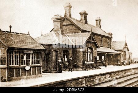 Der ehemalige Kettleness Railway Station an der Whitby nach Middlesbrough Küstenlinie in Yorkshire UK, mit dem Bahnhofsmeister, seiner Frau und Passagieren auf dem Bahnsteig. Stockfoto