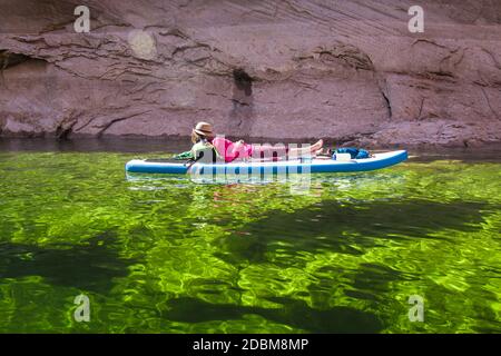 Frau, die sich auf dem Paddle Board, Lake Powell, Utah, USA, entspannt Stockfoto