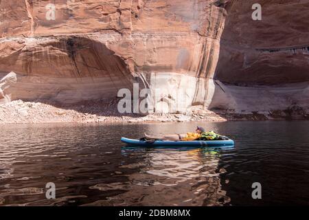 Frau, die sich auf dem Paddle Board, Lake Powell, Utah, USA, entspannt Stockfoto