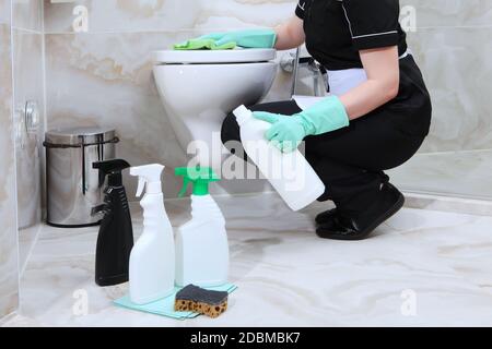 Eine Frau wäscht die Toilette im Marmorbad. Nicht erkennbares Foto. Reinigungsservice im Hotel oder zu Hause. Speicherplatz kopieren. Stockfoto