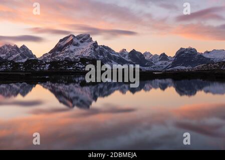 Berggipfel von Moskenesøy spiegeln sich in Fjord bei Sonnenaufgang, Lofoten Inseln, Norwegen Stockfoto