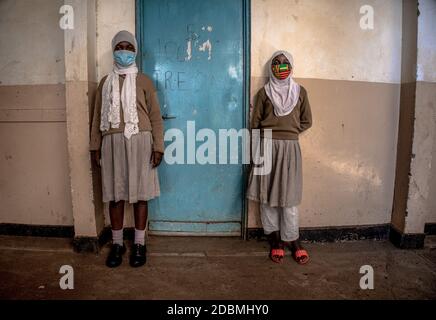 Junge muslimische Schulmädchen, die Gesichtsmasken tragen, als Vorsichtsmaßnahme außerhalb ihres Klassenzimmers an der Ayany Primary School.nach einer langen Zeit der Schließung aufgrund der Coronavirus-Pandemie, wurden die Schulen unter Vorsorgemaßnahmen wie sozialer Distanzierung zwischen den Schülern im Unterricht, regelmäßige Temperaturmessungen der Schüler und Händewaschen mit Desinfektionsmittel wieder eröffnet. Stockfoto