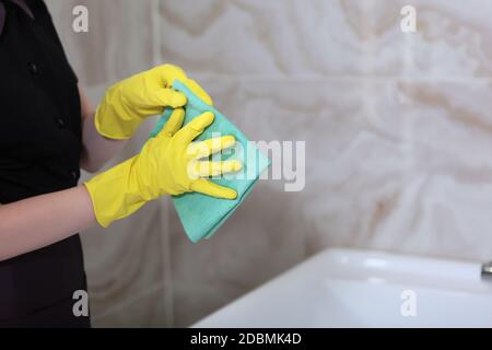 Reinigung im Badezimmer. Marmorfliesen an den Wänden. Nicht erkennbares Foto. Nur Hand. Speicherplatz kopieren. Stockfoto