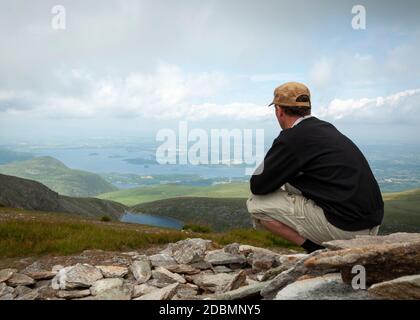 Ein einziger Wanderer bewundert den Blick über die Seen von Killarney und das Tal vom Mangerton Berg im Killarney Nationalpark, Grafschaft Kerry, Irland Stockfoto