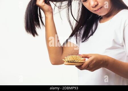 Asiatische Frau unglücklich schwache Haare halten sie Haarbürste mit beschädigten Langverlust Haar in der Kamm Bürste auf der Hand und sie suchen, um Haare, Studio Schuss isoliert o Stockfoto