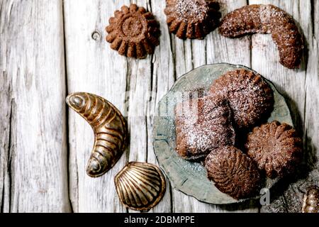 Mürbeteig-Kekse Schoko-Crescents mit Plätzchenformen auf Holz. Draufsicht Stockfoto