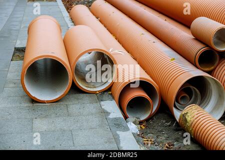 Kunststoff-PVC-Rohre in Reihen auf der Baustelle auf gestapelt Wiederaufbau des städtischen Wassersystems Stockfoto