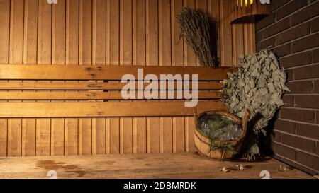 In der Sauna Besen und Eimer vor dem Hintergrund Das Bad aus Holz auf der Seite für die Werbung Stockfoto