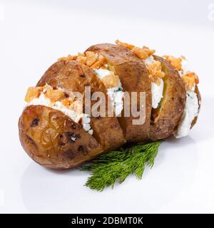Gebackene Kartoffeln mit Quark, frischem Grün, Nüssen und Dill auf weißem Hintergrund. Nahaufnahme. Stockfoto