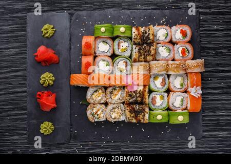 Japanisches Sushi. Maki und Brötchen mit Thunfisch, Lachs, Garnelen, Krabben und Avocado. Draufsicht auf verschiedene Sushi. Regenbogen Sushi Rolle, Uramaki, Hosomaki an Stockfoto