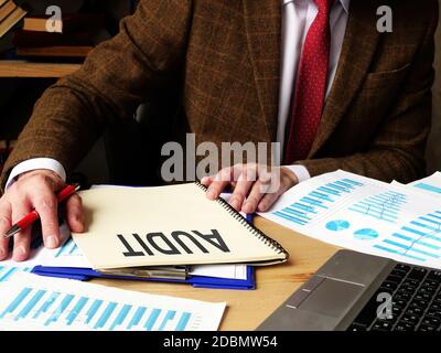 Der Wirtschaftsprüfer schreibt einen Bericht über die Prüfung des Unternehmens. Stockfoto