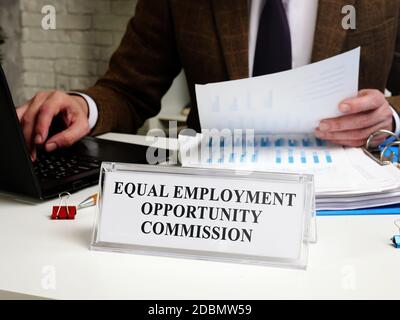 Ein Mann arbeitet an einem Tisch mit einer Tablette EQUAL Employment Opportunity Commission EEOC. Stockfoto