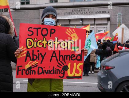 Ottawa, Kanada. November 2020. Protestler mit dem Schild "Stoppet Diktator Abiy Ahmad from dividing US" ein Teil von über 300 Menschen ging auf die Straßen von Ottawa, um gegen den Krieg in der Region Tigray in Äthiopien und die Offensive von Premierminister Abiy Ahmed gegen sie zu protestieren. Sie hielten vor der Botschaft der Vereinigten Staaten von Amerika an, um eine Intervention in den Konflikt zu fordern. Abiy, der Friedensnobelpreisträger des vergangenen Jahres, lehnt weiterhin internationale Bitten um Dialog und Deeskalation im zweiwöchigen Konflikt ab. Kredit: Meanderingemu/Alamy Live Nachrichten Stockfoto