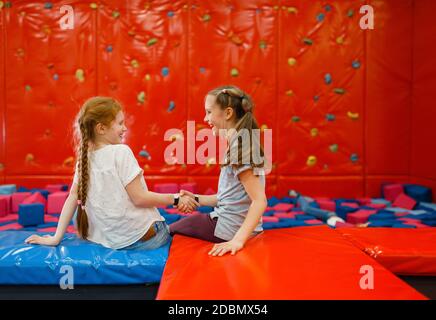 Jouful Freundinnen spielt zwischen weichen Würfel im Entertainment-Center. Mädchen leisures auf Urlaub, Kinderglück, glückliche Kinder auf dem Spielplatz Stockfoto