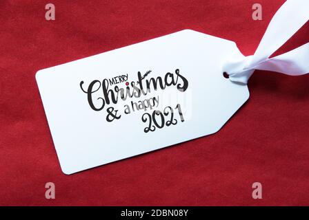 Label mit englischer Kalligraphie Frohe Weihnachten und EIN Happy 2021. Roter Strukturierter Hintergrund Stockfoto