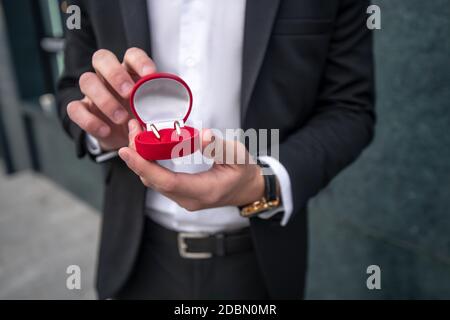 Nahaufnahme der hände von mans, die eine Box mit Engagement halten Klingeln Stockfoto
