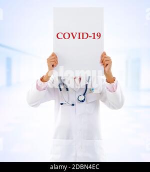 Medizinisches Personal mit einer Karte mit Covid 19 darauf. Stockfoto