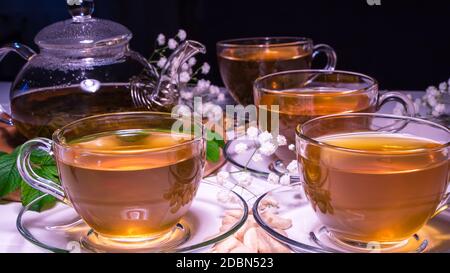 Englischer Tee. Roter heißer Hibiskus-Tee in einem Glas-Becher. Teestunde: tasse Tee, Karkade, Karkade, Rooibos. Orientalisch, gemütlich, Zeremonie, Tradition, Japaner, belaubt, Stockfoto