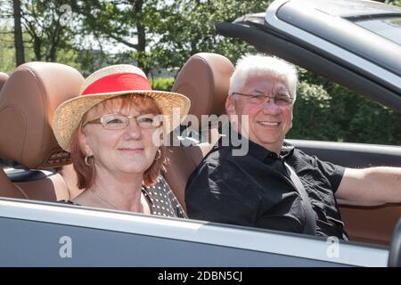 Gerne älteres Paar in einem Luxus Cabriolet Stockfoto