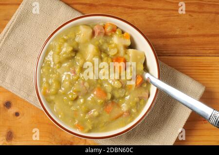 Eine Schüssel mit zersplitterter Erbse und Schinkensuppe, aus der sie geschossen wurden Oben Stockfoto