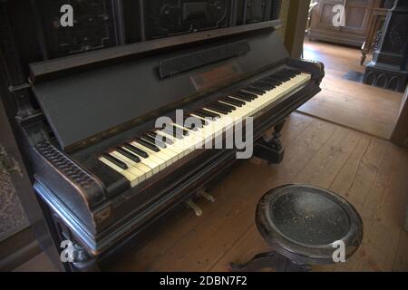 Altes Holzklavier in verlassenen dunklen Zimmer Stockfoto