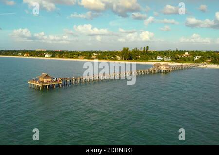 Drohne fliegt in der Nähe eines Pier in Naples, Florida bei Sonnenuntergang, Luftaufnahme. Drohne fliegt um einen Angelpier in Naples, Florida USA. Langer hölzerner Pier Stockfoto