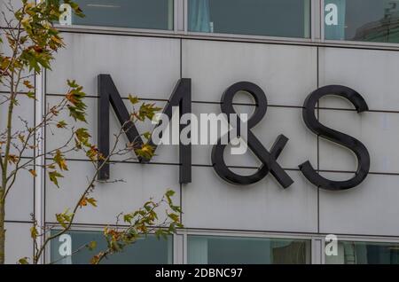 Marks und spencer Ladenschild mit Herbstbäumen neben Markenbanner. Stockfoto