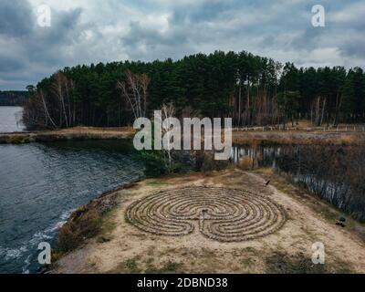 Spirallabyrinth aus Steinen an der Küste, Draufsicht von der Drohne. Stockfoto