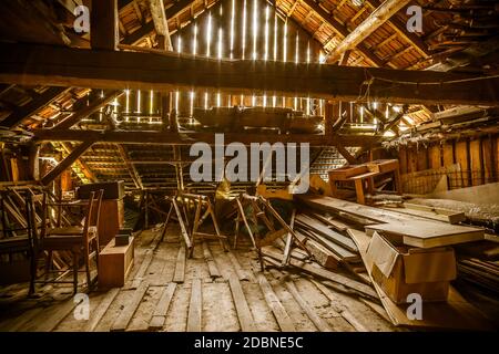 Innenraum des alten Holzschuppen mit Schrottholz mit Sonnenstrahlen. Alte Scheune. Stockfoto