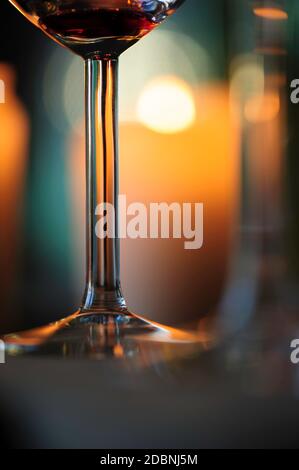 Weinglas Nahaufnahme, Kerzenlicht Bokeh im Hintergrund. Stockfoto