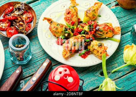 Köstliche gebratene Zucchini Blumen gefüllt mit sonnengetrockneten Tomaten.Sommer Essen. Stockfoto