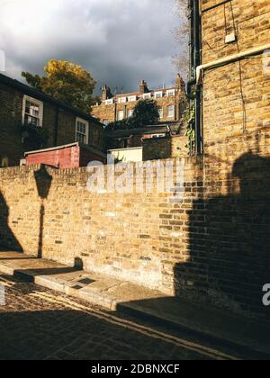 Reihenhäuser von New End, Hampstead, London bei Sonnenuntergang mit Schatten einer altmodischen Straßenlaterne. Stockfoto