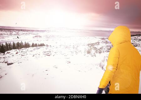 Der Aufbruch-Mann läuft in der isländischen Berglandschaft mit Schnee und Sonnenuntergang der Freiheit der Sonne entgegen Stockfoto
