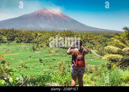 Frau beim Wandern und fotografieren der Aussicht mit Vulkan Agung, Bali, Indonesien Stockfoto