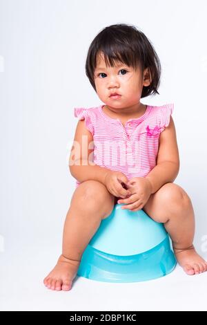 Asiatische kleine niedliche Baby Mädchen Ausbildung Ausbildung auf blauen Kammer Topf oder Töpfchen sitzen in, Studio erschossen isoliert auf weißem Hintergrund, wc WC WC c Stockfoto