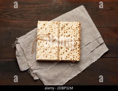 Gebandter Stapel gebackene quadratische Matzoh auf einer grauen Serviette, Draufsicht Stockfoto