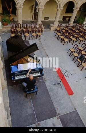 Pianist spielt einen Flügel im Kreuzgang des Alte Kirche von San Francesco in Alghero Stockfoto