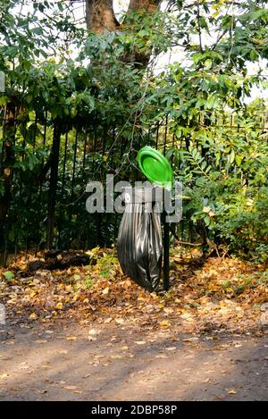 Müll- und Abfalleimer mit schwarzer Mülleinlage und offenem grünen Deckel. Stockfoto