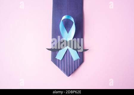 Prostatakrebs-Bewusstsein, hellblaues Band mit Schnurrbart auf blauem Mann-Krawatte für die Unterstützung von Menschen, die leben und erkranken. Männer Healthcare und Weltkrebstag Stockfoto